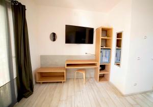 a room with a desk with a tv on a wall at Frontemare Hotel Village & Ristorante in Rodi Garganico