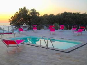 a group of chairs sitting around a swimming pool at Frontemare Hotel Village & Ristorante in Rodi Garganico