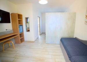 a living room with a bed and a tv and a room at Frontemare Hotel Village & Ristorante in Rodi Garganico