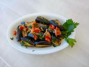 a plate of mussels with parsley on a table at Frontemare Hotel Village & Ristorante in Rodi Garganico