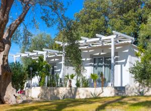 a white house with a tree at Frontemare Hotel Village & Ristorante in Rodi Garganico