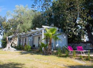 a house with two pink chairs in front of it at Frontemare Hotel Village & Ristorante in Rodi Garganico