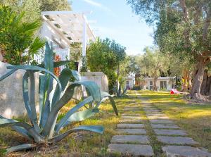 a garden with a stone walkway next to a house at Frontemare Hotel Village & Ristorante in Rodi Garganico