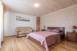 a bedroom with a bed and a chair at Kopų 32 Šventoji in Šventoji