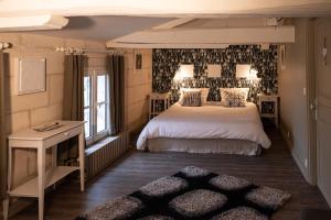 Pont-lʼAbbé-dʼArnoultLa Tillaie SPA et Sauna的卧室里有一张白色的大床和一张书桌