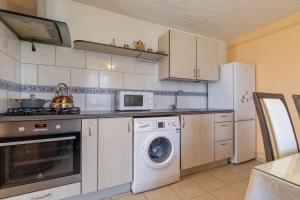 a kitchen with a washing machine and a microwave at Kopų 32 Šventoji in Šventoji