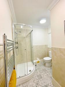 a bathroom with a shower and a toilet at Beautiful chic apartment, lift, views & parking in Scarborough