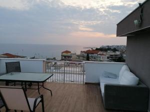 a balcony with a table and a couch at Crystal Blue Apartments in Nea Kalikratia