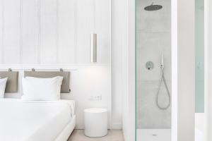 a white bathroom with a bed and a shower at Vila Maria Hotel - Adults Only in Albufeira