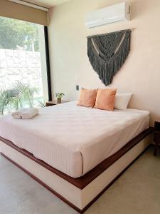 a bedroom with a large white bed with orange pillows at La Veleta luxury condos in Tulum +46 photos