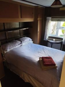 a bedroom with a large bed with a wooden headboard at The Homestead, Cliff-en-Howe Rd, Pott Row, Kings Lynn in Grimston