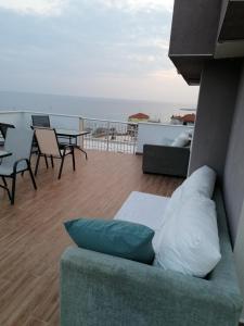 a couch sitting on a balcony with a view of the ocean at Crystal Blue Apartments in Nea Kalikratia