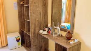 bagno con bancone, specchio e frigorifero. di Summer Vibes Beach Front a Rasdhoo