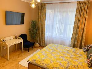 a bedroom with a bed and a desk and a window at Asha Central Apartment in Timişoara