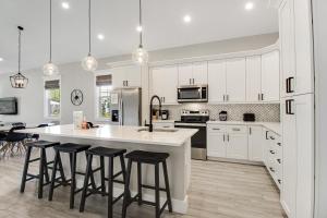 a kitchen with white cabinets and a island with bar stools at Friendly City Fun in Bradenton