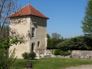 un bâtiment avec une tour au-dessus d'un champ dans l'établissement Gites de Gondieres, à Saint-Éloi