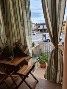 balkon ze stołem, krzesłem i zasłoną w obiekcie Silver Home w mieście Bagnolo San Vito