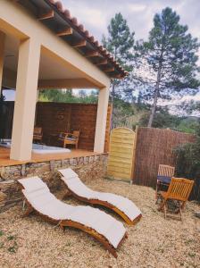 eine Terrasse mit weißen Liegestühlen und ein Haus in der Unterkunft Magnifique petite villa haut de gamme avec jacuzzi l'attrape rêve in Les Plantiers