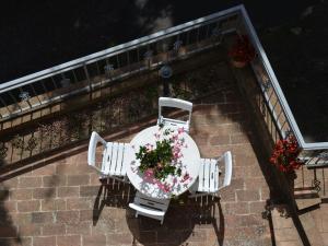 a table and chairs with flowers on a balcony at Charmante Home with Garden in San Valentino