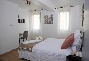 Habitación blanca con cama y escritorio en #Sweet Dreams By Nogar'Homes - WiFi-Netflix-Climatisation en Nogaro