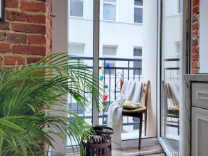 a room with a balcony with a chair and a table at Narutowicza 41 Apartments in Łódź
