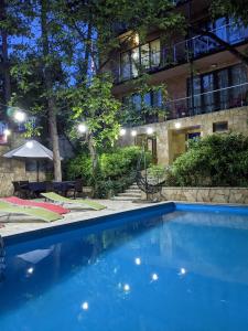 a swimming pool in front of a building at night at Sani Hotel in Tbilisi City