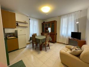 cocina y sala de estar con sofá y mesa en Cozy apartment with private parking on Domaso's lakeside - Larihome A09, en Domaso