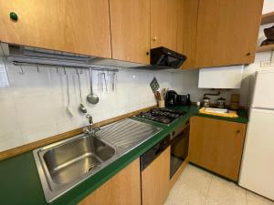 una pequeña cocina con fregadero y nevera. en Cozy apartment with private parking on Domaso's lakeside - Larihome A09, en Domaso