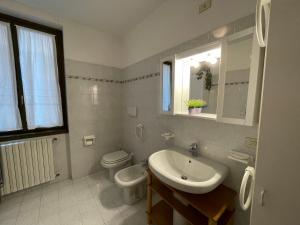Baño blanco con lavabo y aseo en Cozy apartment with private parking on Domaso's lakeside - Larihome A09, en Domaso