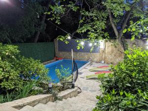 a swimming pool in a garden at night at Sani Hotel in Tbilisi City