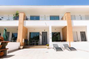 ein Haus mit Stühlen davor in der Unterkunft Sunny villa facing the swimming pool in Fontainhas