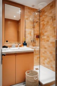 y baño con lavabo y ducha. en Edgar Suites Champs Elysées - Boétie, en París