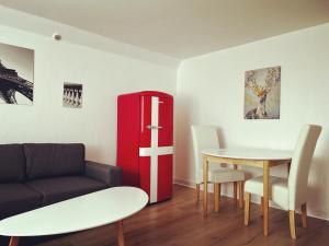 ein Wohnzimmer mit einem Tisch und einem roten Kühlschrank in der Unterkunft Pet-Friendly Apartment 1 30m2 - close to Femern & Puttgarden & Lalandia & Knuthenborg in Holeby