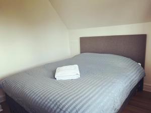 ein Bett mit einem weißen Handtuch darüber in der Unterkunft Pet-Friendly Apartment 1 30m2 - close to Femern & Puttgarden & Lalandia & Knuthenborg in Holeby