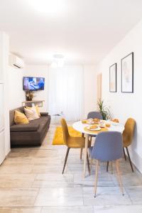 uma sala de estar com uma mesa e cadeiras e um sofá em "Skalinada" Apartments in the Heart of Split em Split