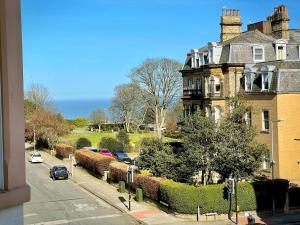 a view of a house with cars parked on the street at Beautiful chic apartment, lift, views & parking in Scarborough