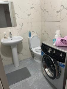 een badkamer met een wasmachine en een wastafel bij Арбат apartment in Alma-Ata