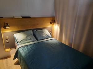 um quarto com uma cama e uma cabeceira em madeira em Mobil Home tout confort em Saint-Hilaire-de-Riez