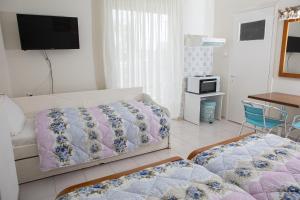 a bedroom with a bed and a tv on the wall at Ronzi Apartments in Kamena Vourla