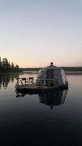 a boat sitting in the water on a lake at AuroraHut Pytkyn Iglu in Syöte