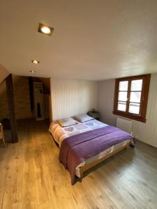 a bedroom with a large bed with a wooden floor at LE PETIT NID in Hunawihr