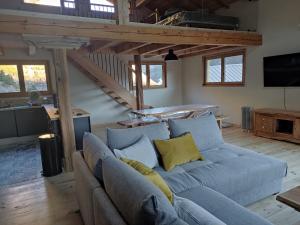 a living room with a blue couch with yellow pillows at CHALET ARLETTE in Les Orres