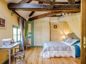 a bedroom with a bed and a table and a desk at Clos du Bois Brard B&B in Saumur