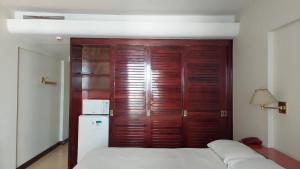 um quarto com uma cama e uma porta de madeira em Flat Particular Hotel Kubitschek em Brasília