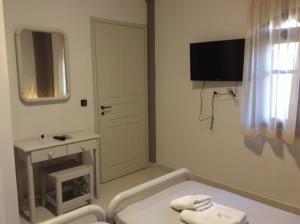 a white bathroom with a table and a mirror at Villa Anna in Syvota