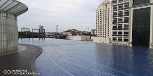 a swimming pool on top of a building with buildings at Ammar @ Troika in Kota Bharu