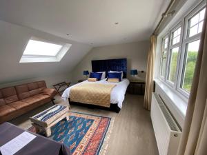 a bedroom with a bed and a couch and windows at Toadhall Rooms in Muchalls