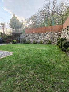 un patio con una pared de piedra y un campo de césped en Apartament JOANNA, en Sanok