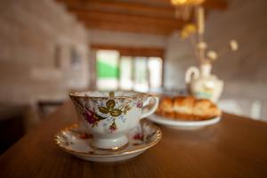 a coffee cup and saucer on a table with a pastry at Narcissos Cave Hotel in Urgup