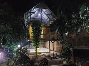 a house at night with a glass roof at Mistvalley Hut in Chithragiri